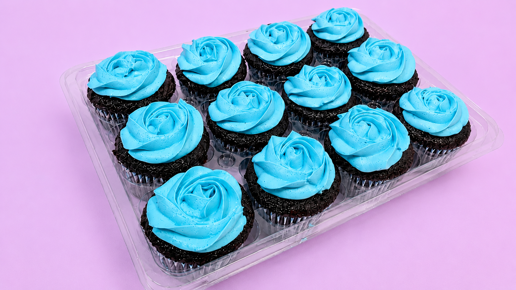 Chocolate cupcakes topped with bright blue buttercream rosette swirls